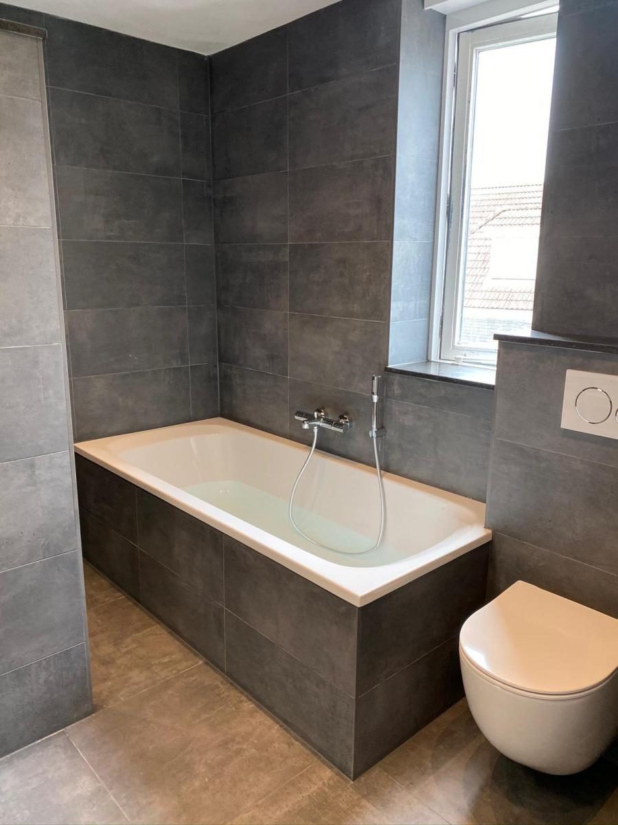 Badkamer 10: ligbad, hangtoilet en eiken meubel