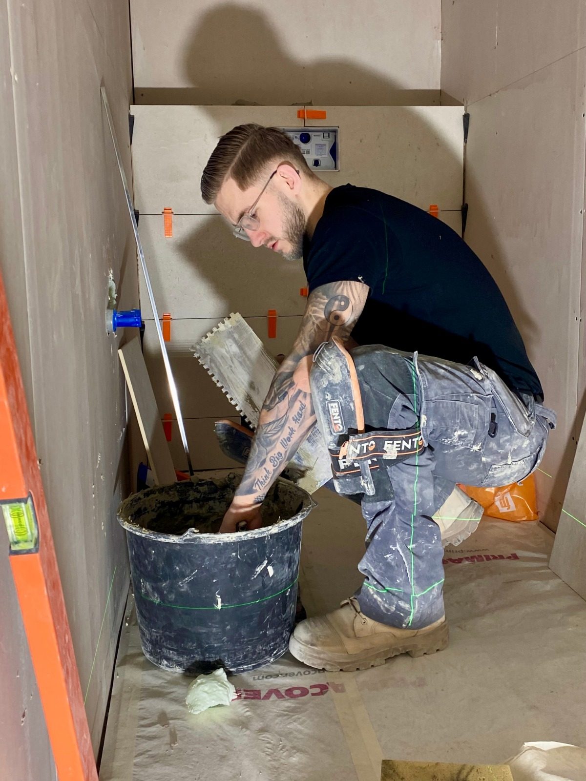 Tom Bakker van Tegelwerk Bakker aan het werk in een badkamer